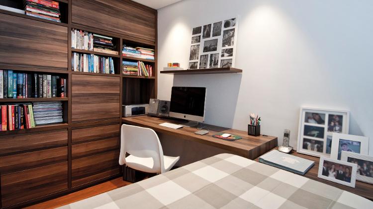 O office no quarto de casal projetado pela arquiteta Pati Cillo (https://www.instagram.com/paticillo_arquitetura/) nasceu a partir da estante, já que os moradores possuem muitos itens para serem acomodados. Livros são mantidos em nichos abertos, enquanto documentos, protegidos por portas. A mesa é uma extensão de uma das aberturas, chegando até a cabeceira da cama que, no dia a dia, fica com cara de sofá. - Luis Gomes - Luis Gomes