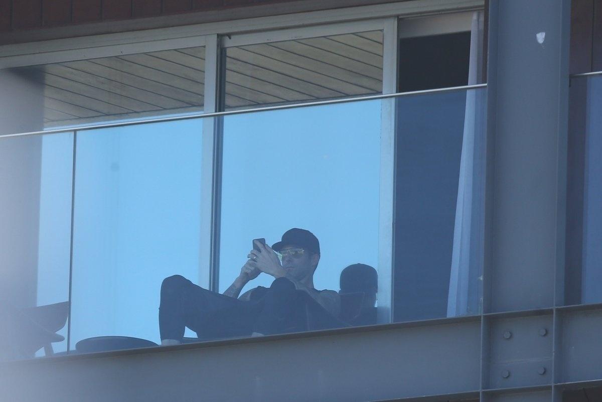 Adam Levine, vocalista do Maroon 5, checa o celular na varanda do hotel Fasano, onde está hospedado no Rio. A banda dele se apresenta nesta sexta-feira no lugar de Lady Gaga e também no sábado no palco Mundo - AgNews