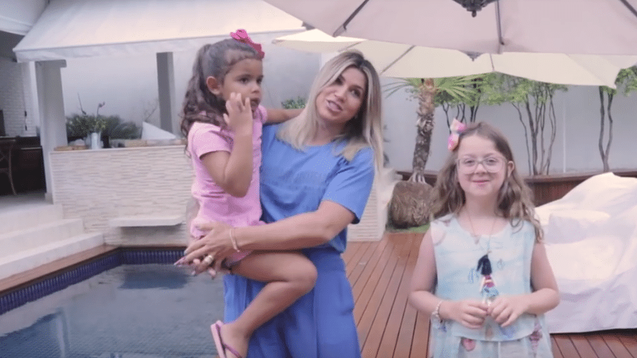Dani Souza com uma das filhas no colo e uma amiguinha delas em sua mansão em Florianópolis - Reprodução/Youtube