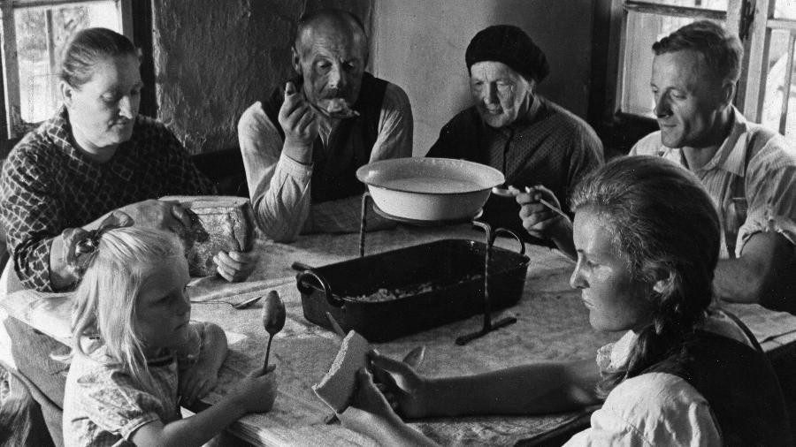 Família alemã consome o milchsuppe, sopa de leite, em retrato de 1935 - ullstein bild Dtl./ullstein bild via Getty Images