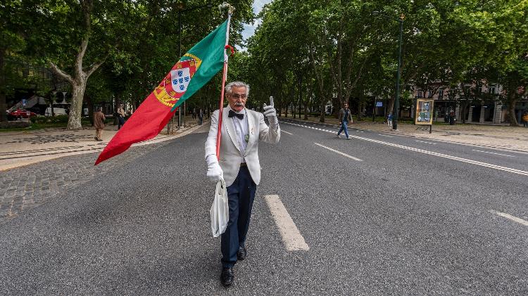 Carlos Alberto Ferreira, de 72 anos, carrega solitário a bandeira de Portugal na Avenida Liberdade durante a celebração da Revolução do Cravos - Corbis/Getty Images