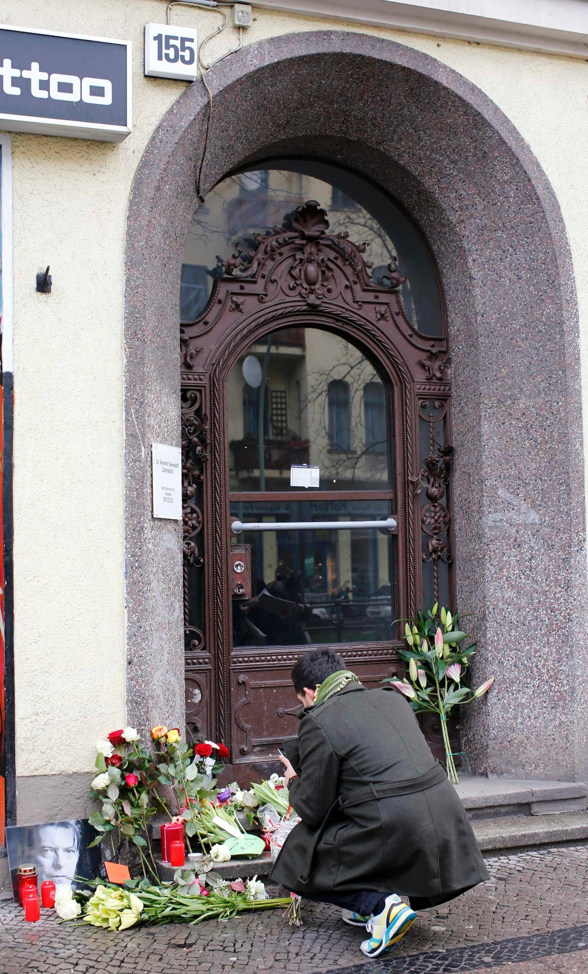 11.jan.2016 - Fã tira fotos das flores deixadas em frente ao apartamento onde David Bowie estava morando em Berlim, na Alemanha. - Fabrizio Bensch/Reuters