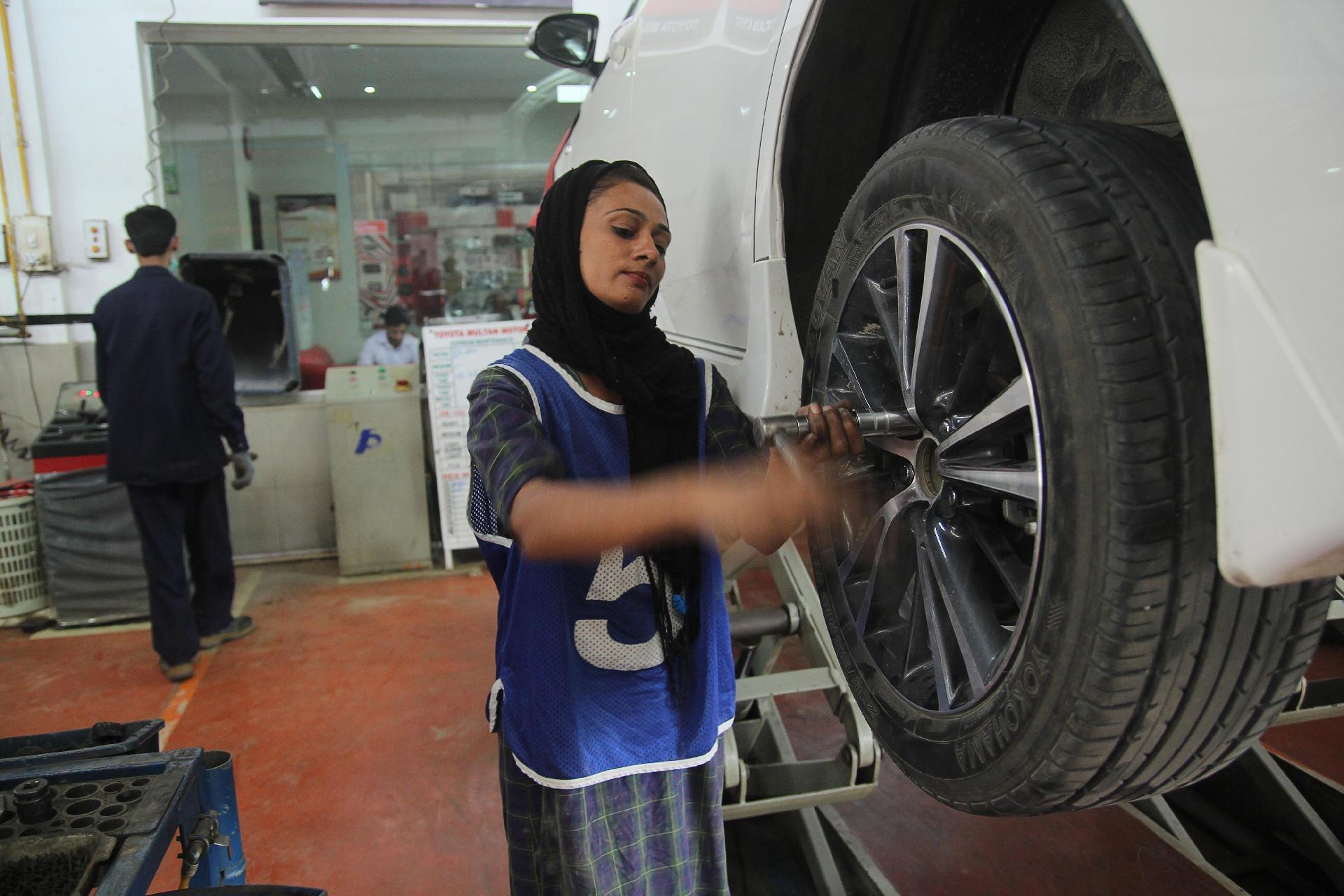 Uzma Nawaz conserta carro em uma oficina de Multan - S.S.Mirza/AFP