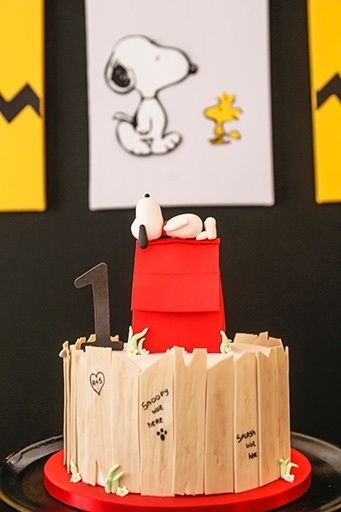 O bolo cenográfico, da Nika Linden, tinha o Snoopy dormindo em cima da casinha, além do tradicional muro de madeira que aparecia na atração - Divulgação