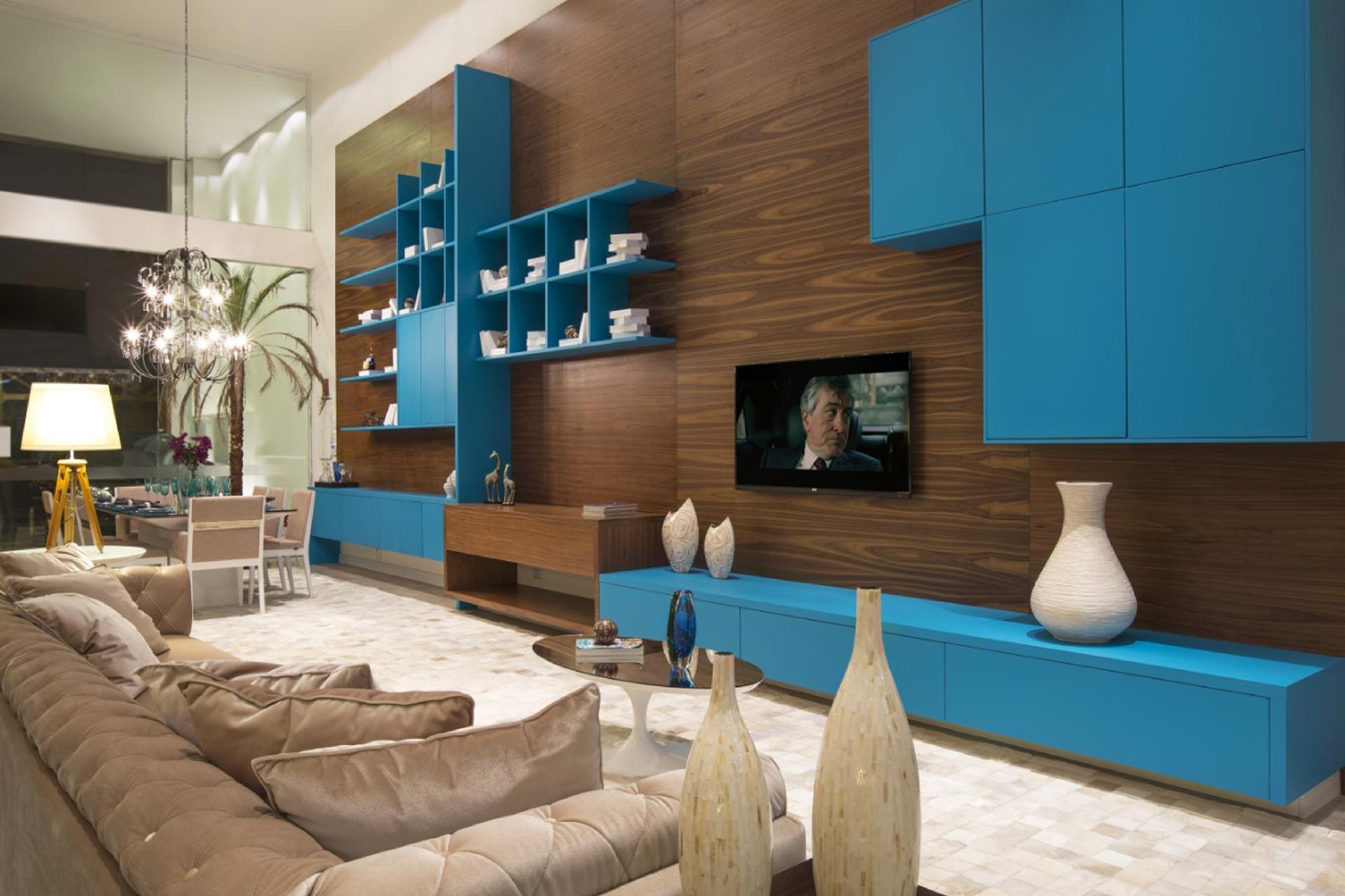 Organizar and decorar: taí a proposta das prateleiras com pintura de laca fosca criadas pela Grecco. Os nichos irregulares, com vãos dispersos em diferentes direções, trazem movimento para a sala de jantar, e são úteis para acomodar peças decorativas, livros, porta-retratos etc. De quebra, ainda conversam com o armário fechado da sala adjacente. O azul intenso ainda traz vida para os ambientes integrados. - Junior Fiocco