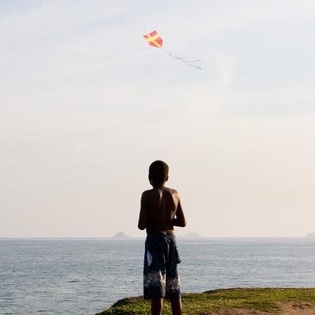 Menino empina pipa de frente para o mar de Ipanema, no Rio - Getty Images/iStockphoto