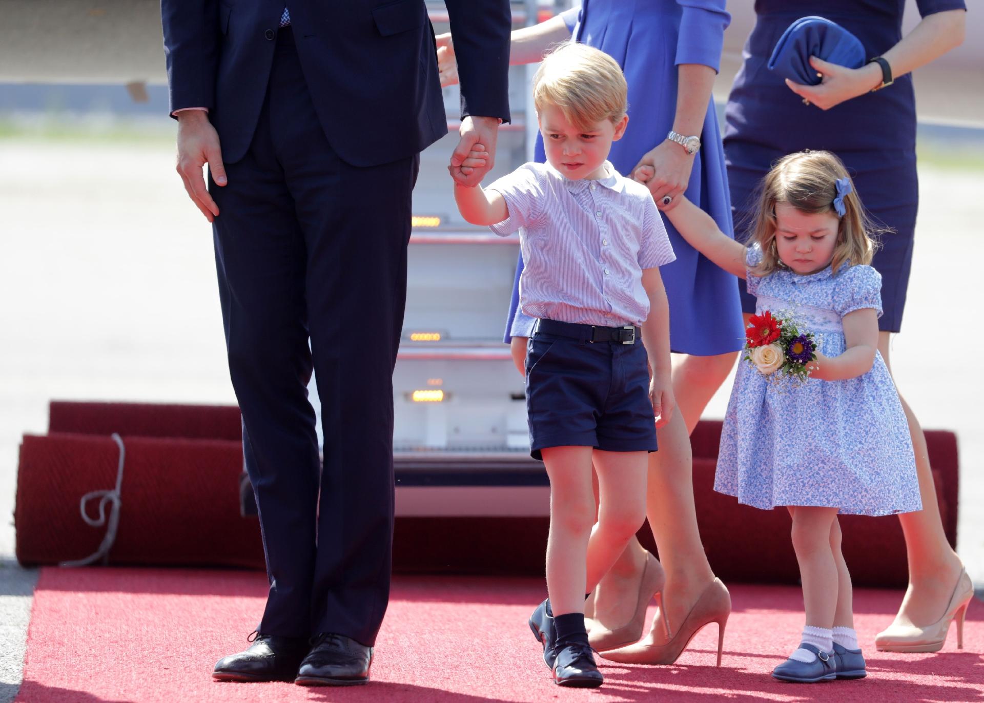 Sonolento, príncipe George esfrega o rosto ao desembarcar com os pais na Alemanha - AFP PHOTO/POOL/Kay Nietfeld