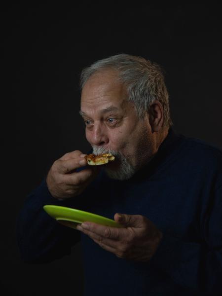 Homem idoso come pizza - iStock - iStock
