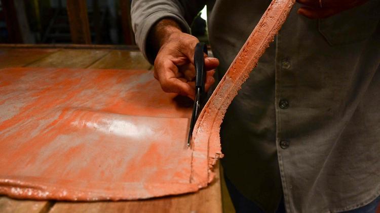 Trabalhador manuseia borracha processada na fábrica da Seringô, onde toda a matéria-prima para a produção de calçados de borracha é fabricada, perto da cidade de Castanhal, no estado do Pará