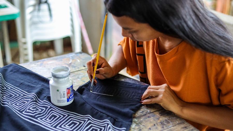Erika Witoto desenha a estampa de tartaruga em uma blusa na sede do Ateliê Derequine em Manaus Erika Witoto desenha a estampa de tartaruga em uma blusa na sede do Ateliê Derequine em Manaus