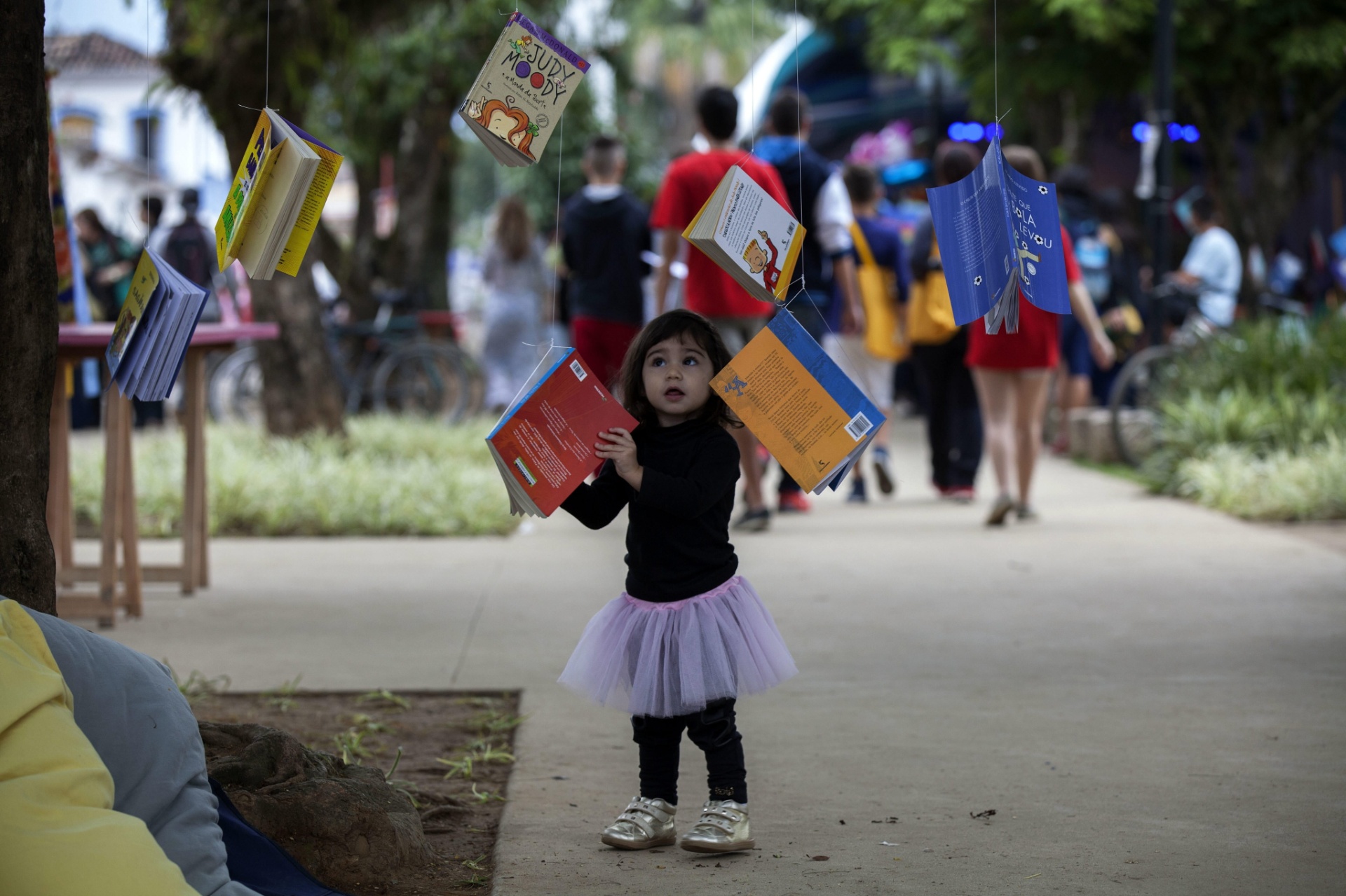 3.jul.2015 - Criança observa livros amarrados nas árvores na praça da Matriz, centro de Paraty, durante a 13ª edição da FLIP 2015 - EFE/Sebastião Moreira