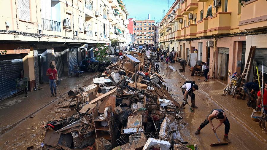 Destroços são amontoados após os efeitos devastadores das inundações na cidade de Paiporta, no leste da Espanha