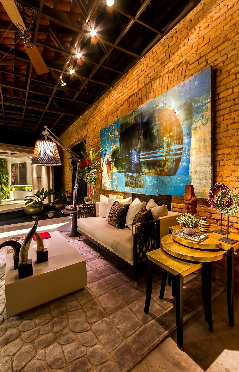 Outro destaque da criação de Humberto Beltrán, mostrado na edição boliviana da Casa Cor, é a sala de estar, antes de chegar ao loft do projeto Penthouse. As paredes tem referências rústicas, como o tijolo aparecendo, e o trio de móveis como as mesinhas laterais é um dos destaques da decoração - Alvaro Mier/ Divulgação