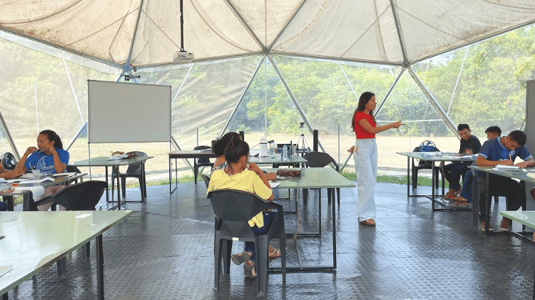 Jhanne Franco dá aula para membros da comunidade dentro de um dos domos geodésicos onde funciona a biofábrica