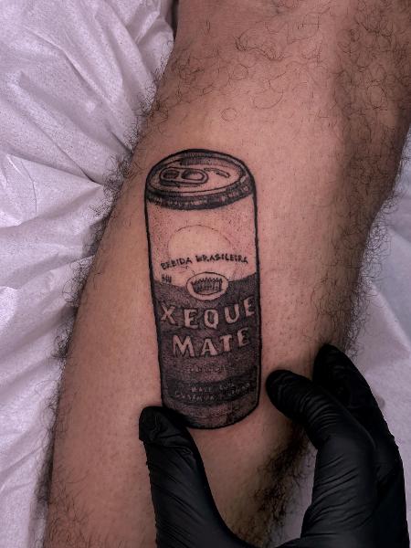 Lata da bebida Xeque Mate tatuada na perna direita do estudante Luiz Eduardo, 20