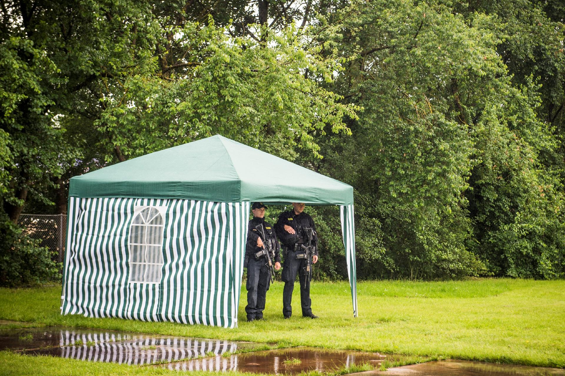 Ao lado de uma poça de lama, policiais armados fazem a segurança dos arredores do Festival de Roskilde - Ida Marie Odgaard/Reuters