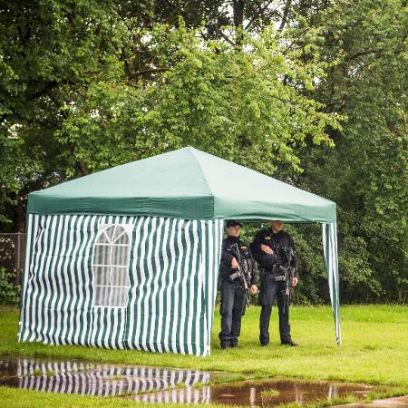 Ao lado de uma poça de lama, policiais armados fazem a segurança dos arredores do Festival de Roskilde - Ida Marie Odgaard/Reuters - Ida Marie Odgaard/Reuters