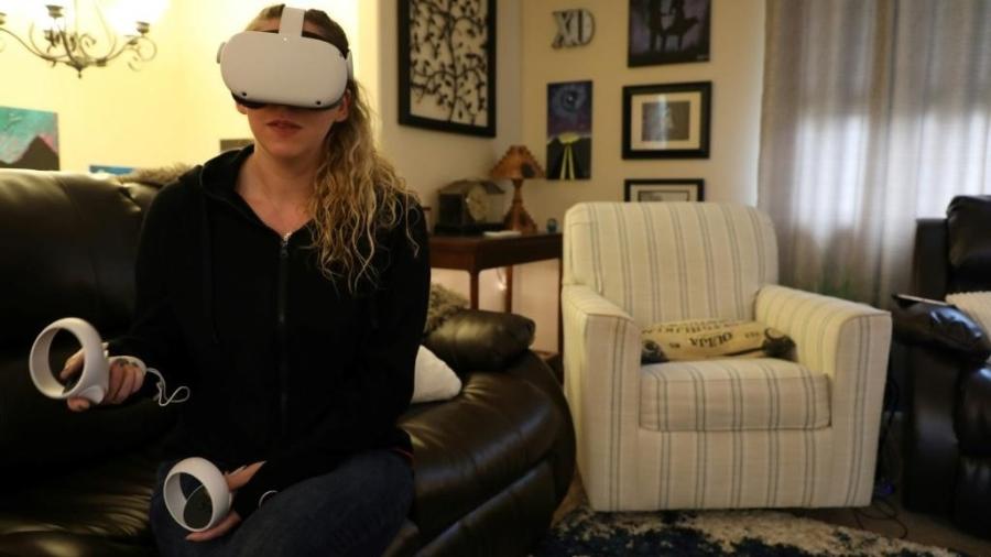 Amy Erdt, moderadora de um grupo de realidade virtual no Facebook, viaja de sua sala de estar em Oregon para várias partes do mundo graças a seu fone de ouvido Oculus - AFP