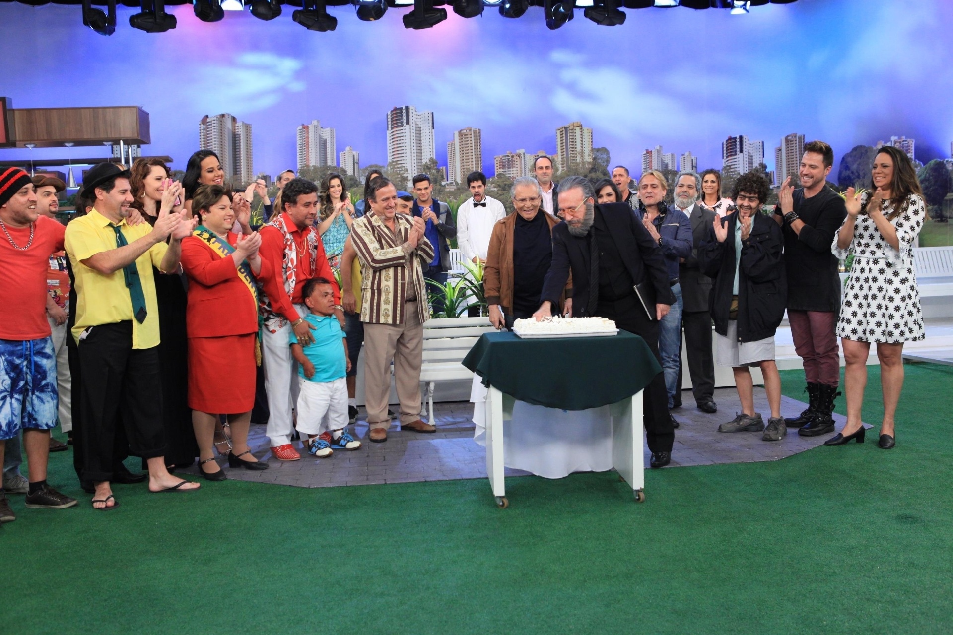 No final da festa surpresa, quando os atores da "Praça" acabaram de cumprimentar e cantar parabéns, Moacyr enfiou a mão no bolo e jogou no elenco. A comemoração, que irá ao ar nesta quinta-feira (6), terminou em "chuva" de bolo - Leonardo Nones/SBT