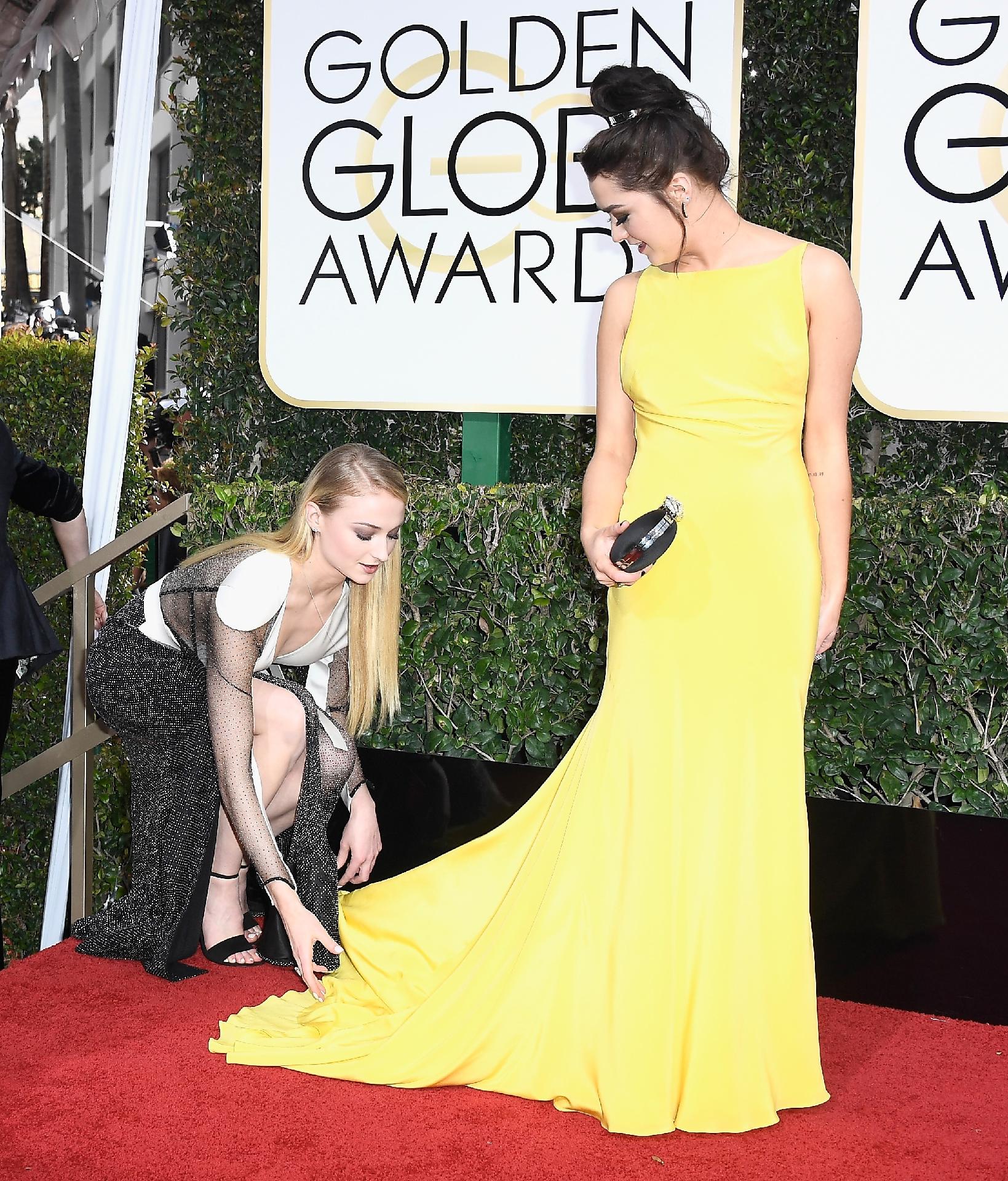 Amigas, Maisie Williams (Arya Stark) e Sophie Turner (Sansa Stark) chegaram juntas ao tapete vermelho e Sophie Turner  ajudou Maisie com o vestido para sair bem na foto - Getty Images