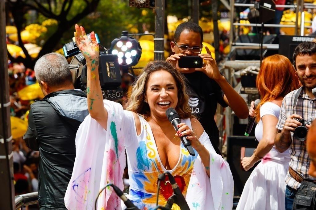 Artista pinta vestido branco de Daniela Mercury durante desfile do bloco Pipoca da Rainha, na rua da Consolação, em São Paulo - Marcelo Justo/UOL