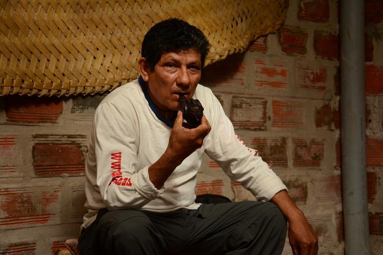 Curandeiro Hernán Saavedra com cachimbo de mapacho em sessão de ayahuasca