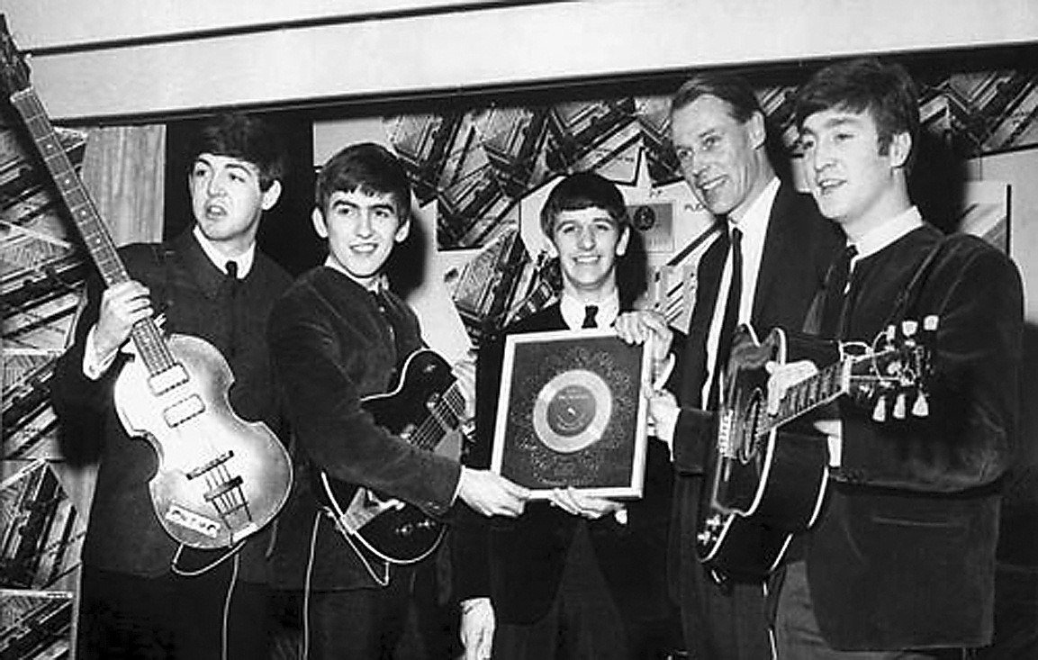 Os Beatles posam ao lado do produtor musical George Martin, em 1963. Ele ajudou Ringo, Paul McCartney, John Lennon e George Harrison a alcançar o estrelato, com cerca de trinta canções chegando ao primeiro lugar das paradas no Reino Unido - Reprodução