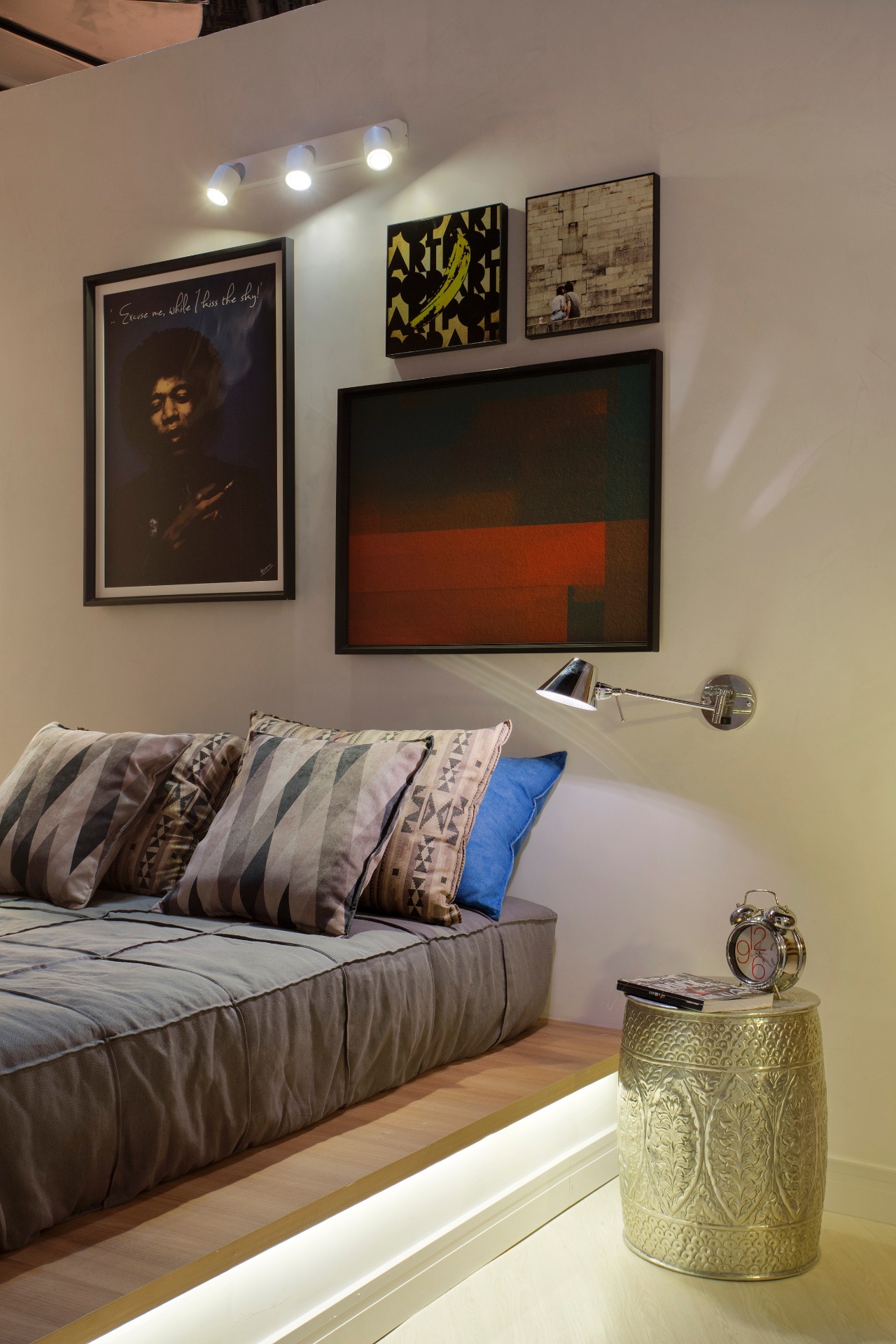 Para arrematar o visual descontraído do quarto, uma dica é substituir a cabeceira por uma bonita composição de pinturas, pôsteres e fotografias. Para iluminar e destacar a parede decorada, os arquitetos Nilton Montarroyos e Estela Pinheiro instalaram, acima dos quadros, um pequeno trilho com três spots | O projeto está exposto na Morar Mais por Menos RJ (www.morarmais.com.br) até 2 de novembro de 2015 - Denílson Machado/ MCA Estúdio/ Divulgação