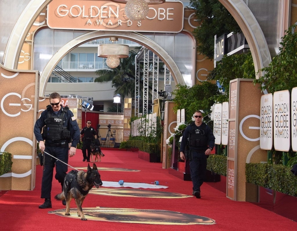 Policiais com cães farejadores verificam as instalações do 73º Globo de Ouro logo após a abertura da premiação em Beverly Hills, na Califórnia (Estados Unidos) - AFP