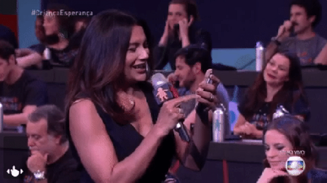 2.jul.2016 - Dira Paes pegou o celular, ligou para a central de atendimento da campanha e pediu ao telespectador para que também fizesse a sua doação para a campanha beneficente da Globo - Reprodução/TV Globo