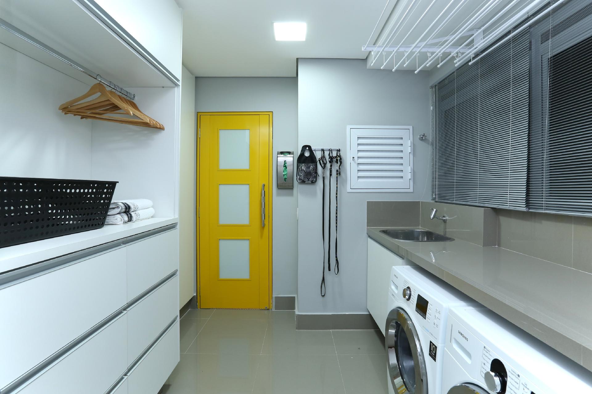 Pensada como um lugar funcional, a lavanderia proposta pela Spaço Interior tem armários sob medida para acomodar utensílios domésticos, lavadora, secadora e varal. Há até um local para pendurar as coleiras e acessórios do pet, além de uma alegre combinação de cores - Mariana Orsi | Divulgação