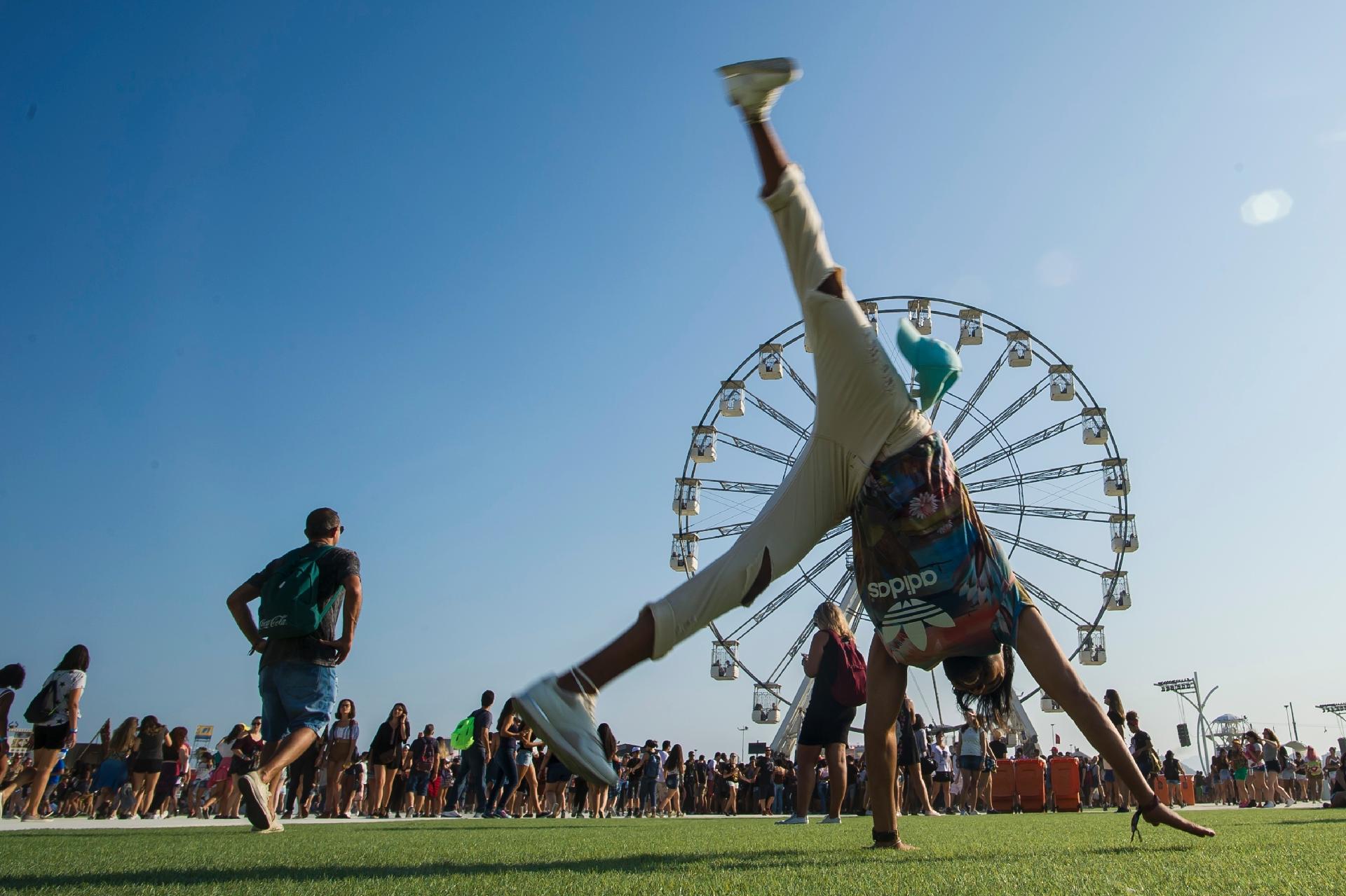Fã faz pirueta em frente a roda-gigante da Cidade do Rock, no Parque Olímpico, na abertura do segundo dia do Rock in Rio 2017 - Bruna Prado/UOL