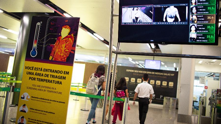 Viajantes passam por monitor de temperatura no aeroporto de Brasília - Getty Images