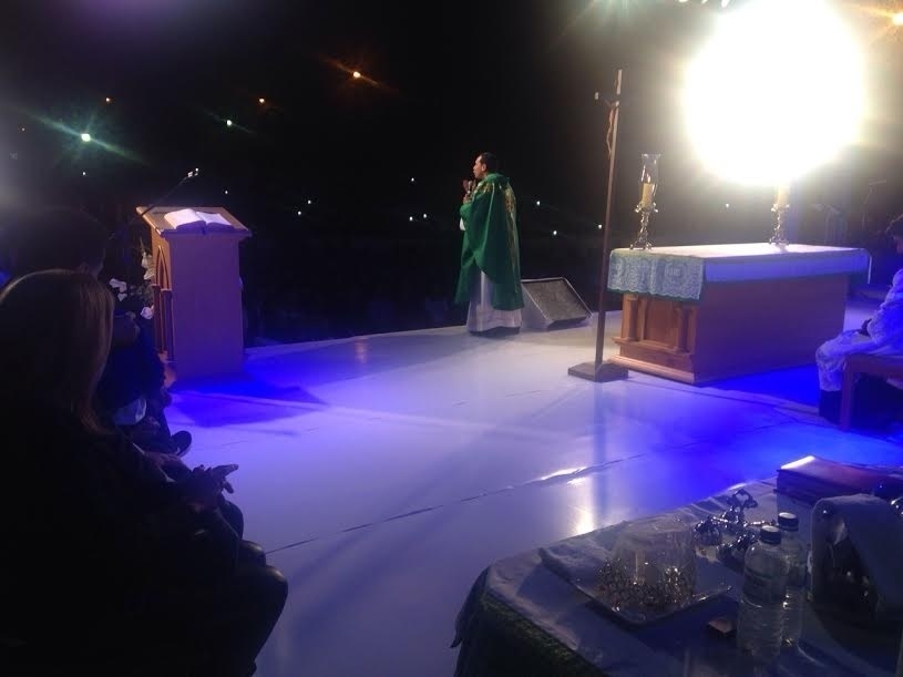 O padre Marcos Rogério, amigo de Cristiano Araújo, celebra a missa de sétimo dia do cantor em palco montado no estacionamento da paróquia - Luciana Vitorino/UOL