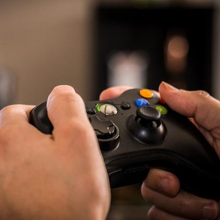 Diversos grupos de pessoas que gostam de videogames jogam no console de  jogos, se divertindo com