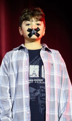 13.jul.2015 - O ator mirim Kalebe Figueiredo, de 10 anos, usa fita na boca em protesto à proibição de crianças no espetáculo "Memórias de Um Gigolô", em cartaz no Teatro Procópio Ferreira, na zona sul de São Paulo, na noite desta segunda-feira
