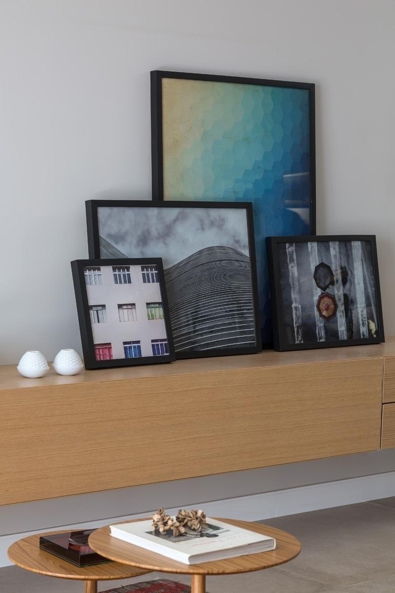 Nada de quadros pendurados na parede de uma forma convencional. Aqui, as fotografias com molduras pretas (Urban Arts) e diversos tamanhos ficam apoiadas sobre o bufê de um jeito descontraído - Evelyn Müller/Divulgação