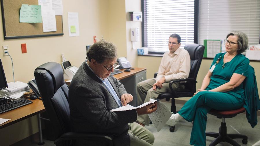 O especialista em câncer Oliver Sartor analisa as anotações dos pacientes com o Dr. Brian Lewis e Mary Livaudais, uma enfermeira, em seu consultório no Tulane Medical Center, em Nova Orleans - Annie Flanagan / The New York Times