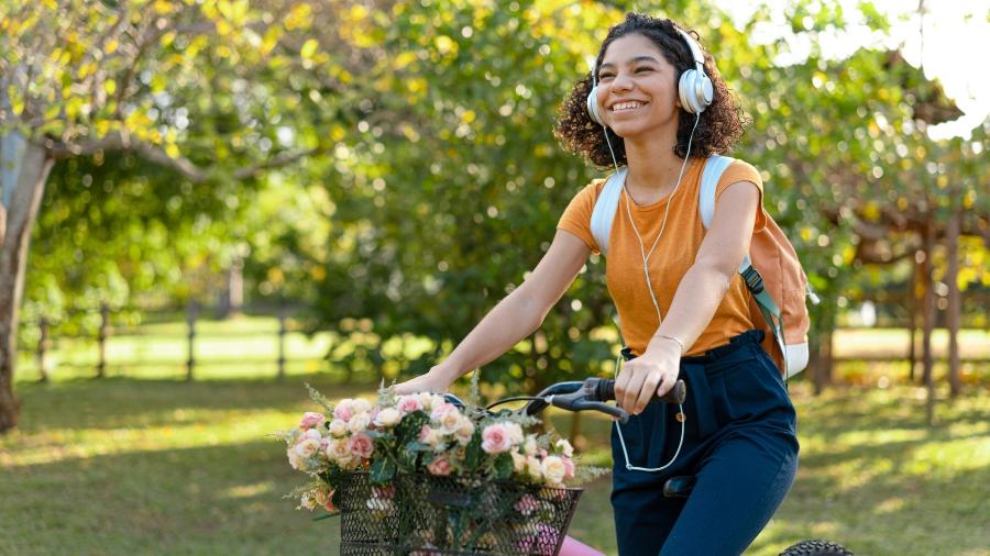 Garota anda de bicicleta com cesta de flores - MesquitaFMS/Getty Images
