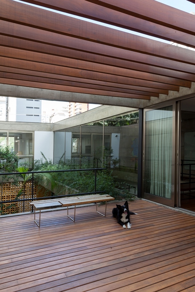 No pavimento superior, a varanda coberta por pergolado de madeira é aberta nas laterais com vista para os jardins. Banco Tiras, da Ovo. A Casa Jardins foi projetada pelo escritório CR2 Arquitetura - Fran Parente/ Divulgação