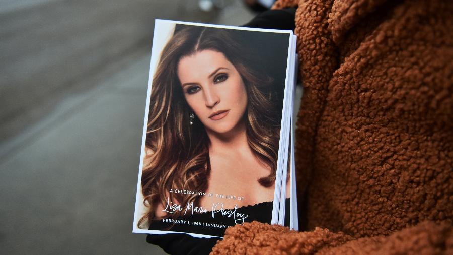 Fã segura folheto distribuído no velório de Lisa Marie Presley - Justin Ford/Getty Images