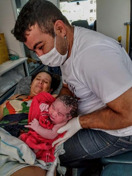 Michaella Mignone, após o parto, com o bebê e um socorrista - Arquivo pessoal