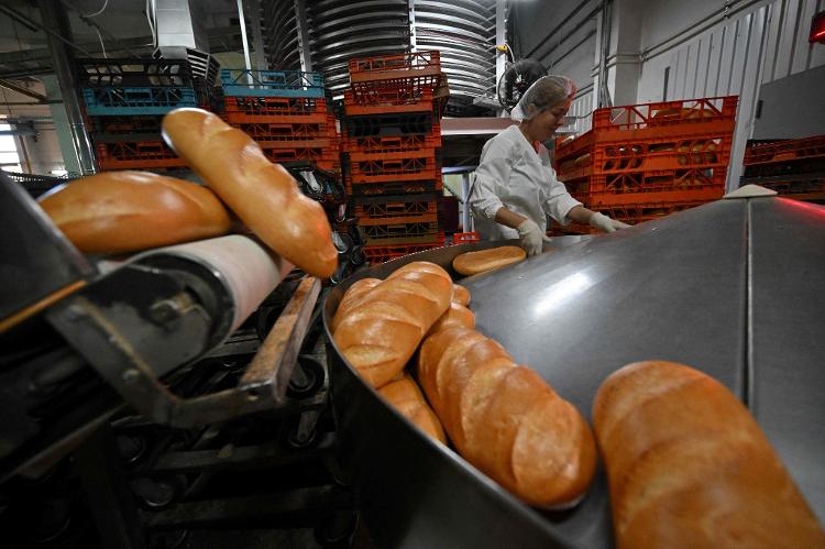 An employee checks the quality of bread at the Tsar-Khlib factory in the village of Novi Petrivtsi, near Kyiv, on May 25, 2022.  SERGEI SUPINSKY/AFP - SERGEI SUPINSKY/AFP