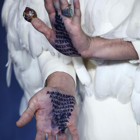 Ezra Miller mostra as mãos com o escrito "avada kedrava" na pré-estreia de "Animais Fantásticos 2" em Londres - John Phillips/Getty Images - John Phillips/Getty Images