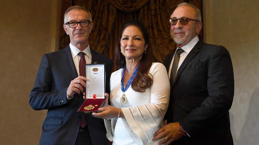 Gloria Estefan recebe medalha de ouro das artes do governo da Espanha das mãos do ministro da Cultura e Esportes Jose Guirao. À sua direita, o marido Emilio Estefan - PIERRE-PHILIPPE MARCOU/AFP