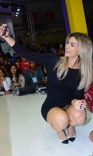 6.set.2015- De vestido curtinho, Kelly Key quase mostra a calcinha ao fazer selfie com fãs em evento de beleza em São Paulo