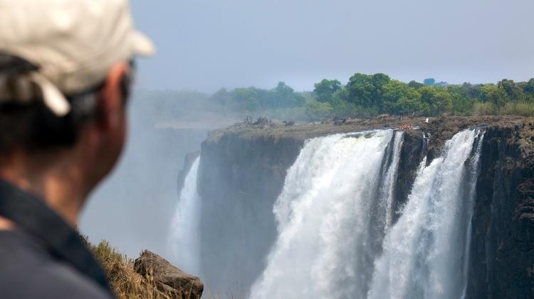 Ao fundo da foto, é possível ver turistas curtindo a "Piscina do Diabo" à beira do precipício - Getty Images - Getty Images