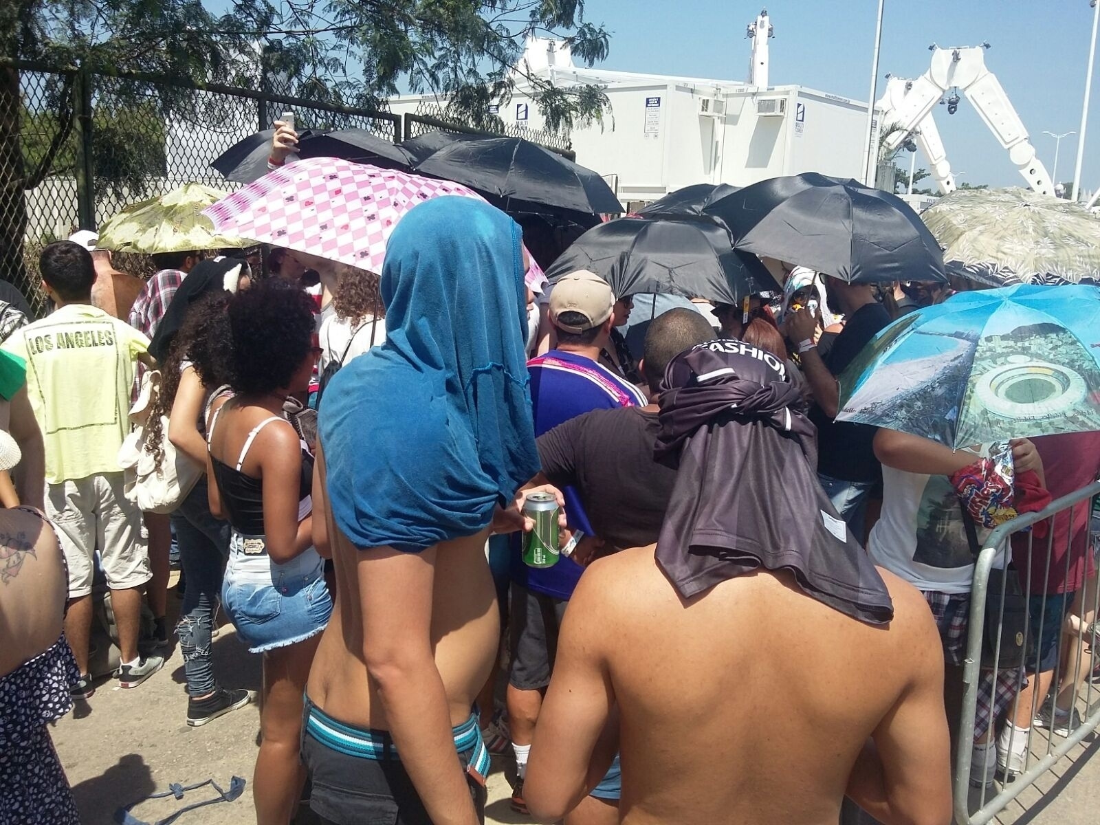 18.set.2015- Para se proteger do sol forte do Rio nesta sexta (18), muita gente usa guarda-chuva na fila para entrar na Cidade do Rock, a partir das 14h - Marcela Ribeiro/UOL