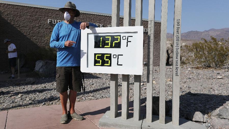 Turista posa ao lado do registro de 55°C, no Vale da Morte. Esta temperatura pode ser recorde de calor no mundo - Getty Images
