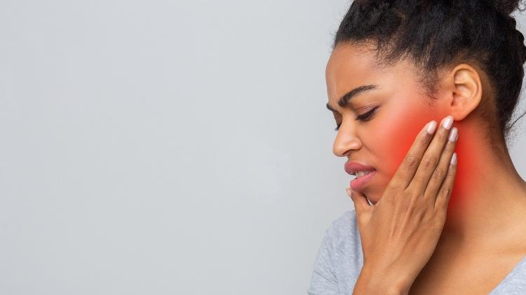Mulher jovem com dor na mandíbula, DTM, ATM - iStock - iStock